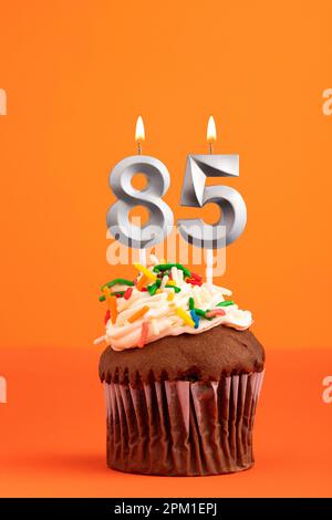 Bougie numéro 85 - gâteau anniversaire dans fond orange Banque D'Images