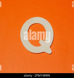 Lettre majuscule Q - texture bois - fond orange Banque D'Images