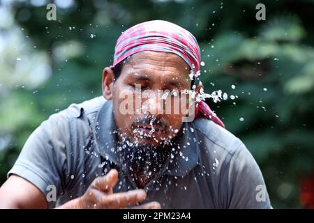 Dhaka, Bangladesh. 11th avril 2023. Des gens se lavant le visage avec de l'eau à un pipeline en bord de route pendant les journées météorologiques à haute température à Dhaka, au Bangladesh, sur 11 avril 2023. Photo de Habibur Rahman/ABACAPRESS.COM crédit: Abaca Press/Alay Live News Banque D'Images