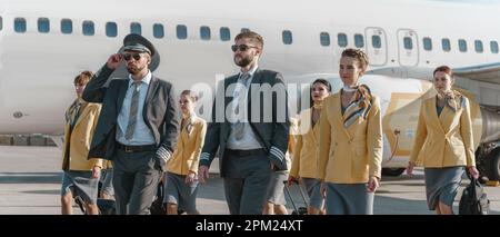 Des pilotes et des agents de bord descendent sur le terrain d'aviation après l'atterrissage Banque D'Images