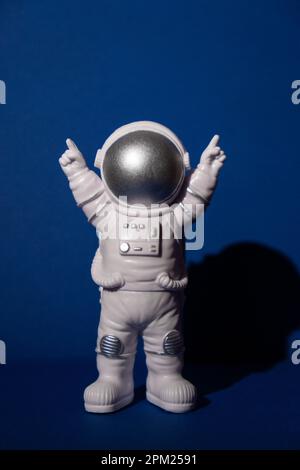 Astronaute jouet en plastique sur fond bleu coloré espace de copie. Concept de voyage hors terre, vols commerciaux privés de spaceman. Missions spatiales et durabilité Banque D'Images