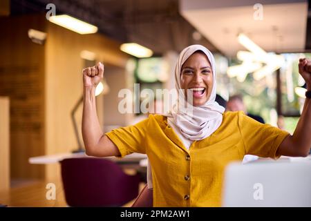 Portrait d'une femme d'affaires mûre excitée portant un foulard célébrant le travail au bureau au bureau Banque D'Images