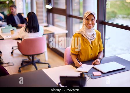 Femme d'affaires mature portant un foulard travailler au bureau écrire au bureau dans un ordinateur portable Banque D'Images