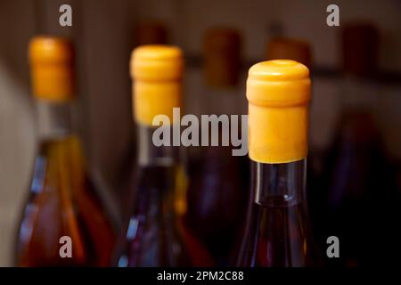 Bouteilles de vin sur des étagères en bois dans un domaine viticole. Banque D'Images