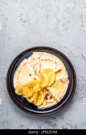 Plaque de crêpes orange sur fond gris, directement au-dessus. Crêpes Suzette Banque D'Images