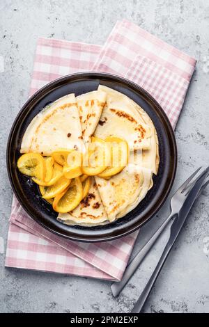 Plaque de crêpes orange sur fond gris, directement au-dessus. Crêpes Suzette Banque D'Images