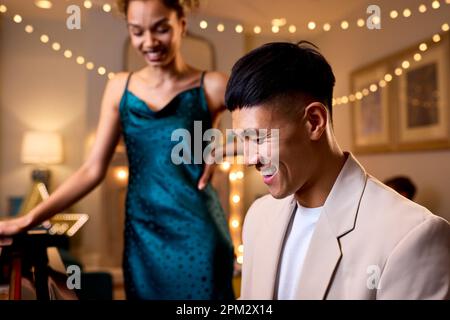 Couple autour de Piano célébrant à Noël ou fête du nouvel an ensemble Banque D'Images