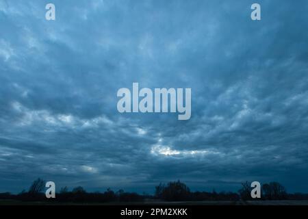 Abstrait nuages de tempête sombre sur les arbres, vue de printemps en soirée Banque D'Images