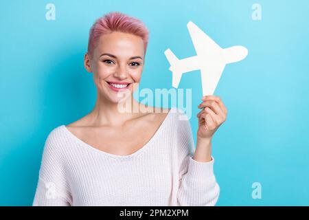 Portrait photo de jeune gaie adorable fille porter blanc à manches longues papier origami avion jouet profiter de voyage à la mouche isolé sur fond de couleur cyan Banque D'Images