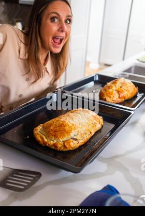 Jeune femme heureuse avec son Wellington de boeuf maison avec une pâte feuilletée Banque D'Images