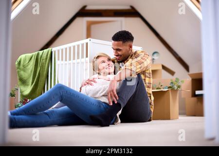 Couple s'attendant à bébé se détendre dans la pépinière de la nouvelle maison avec déplacer dans des boîtes Banque D'Images