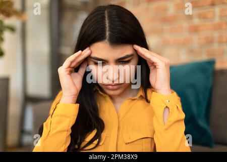 Concept d'apathie. Une dame espagnole déprimée se touchant la tête, bouleversée une jeune femme souffrant d'une dépression ou d'une dépression nerveuse Banque D'Images