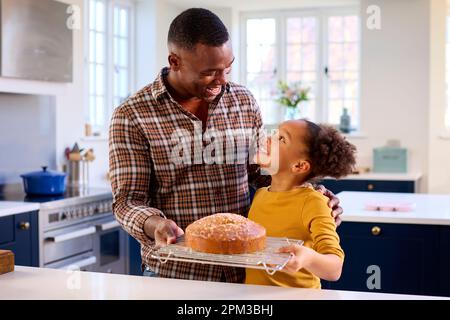 Fier Père et fille à la maison dans la cuisine avec gâteau fait maison ils ont cuit ensemble Banque D'Images