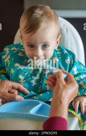 Grand-mère nourrissant son petit-fils souriant Banque D'Images