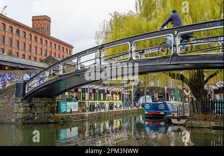 Camden Town, Londres, Royaume-Uni : un cycliste sur une passerelle traversant le canal Regents près du marché de Camden avec un saule. Banque D'Images