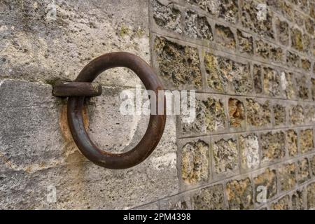 Gros plan d'un anneau d'amarrage en fer sur un mur de pierre le long de la Seine à Paris, France. Banque D'Images