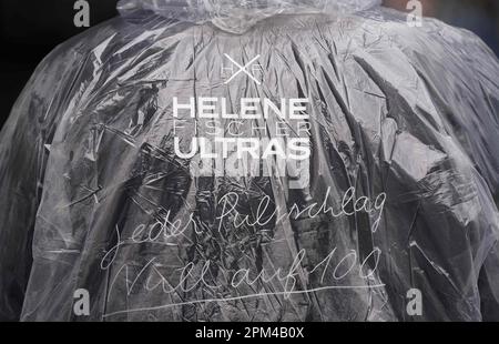 Hambourg, Allemagne. 11th avril 2023. Un fan d'Helene Fischer se tient avec un poncho de pluie et l'inscription 'Helene Fischer Ulras - chaque impulsion battait zéro à cent' devant la Barclays Arena, où dans la soirée la chanteuse Helene Fischer commence sa tournée 'Rausch' avec le premier des cinq concerts de Hambourg. Le chanteur a dû reporter le départ de la tournée à Brême et le concert à Cologne en raison d'une fracture de la côte. Credit: Marcus Brandt/dpa/Alay Live News Banque D'Images