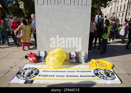 Une bannière et des messages soutenant le fondateur de WikiLeaks, Julian Assange, sont exposés autour de la statue de Winston Churchill sur la place du Parlement, à Londres. Banque D'Images