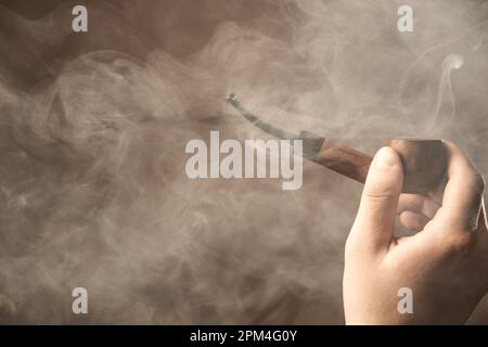 Un homme fume un tuyau et lit un journal. Style rétro. Banque D'Images