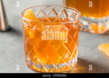Un cocktail à l'ancienne bourbon froid accompagné d'une tranche d'orange Banque D'Images