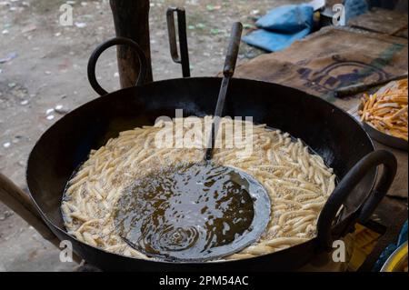 Howrah, Bengale-Occidental, Inde - 26.10.2020 : Nimki, une nourriture épicée indienne très populaire est en cours de préparation dans une cabine de nourriture du côté de la route. Banque D'Images