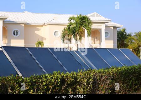 Panneaux solaires sur le fond de la villa et des palmiers. Énergie électrique écologique propre Banque D'Images