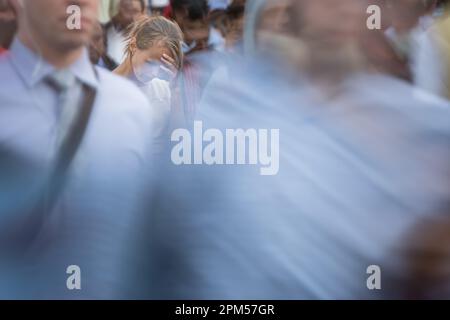 Foule de personnes marchant dans la rue de la ville - mouvement image floue avec des visages méconnaissables - jeune femme debout, debout, se sentant, déprimé Banque D'Images