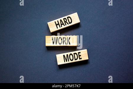 Symbole du mode travail dur. Mots-clés mode de travail dur sur bloc de bois sur un beau tableau noir fond noir. Concept de mode Business et Hard Work. Banque D'Images