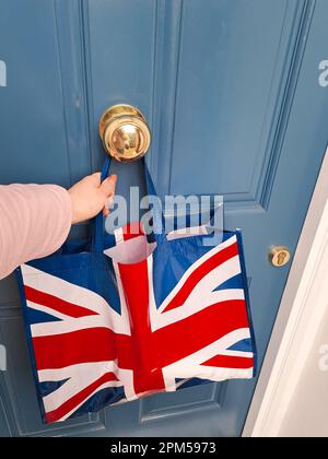 sac de shopping avec drapeau britannique près de la porte bleue. Photo de haute qualité Banque D'Images