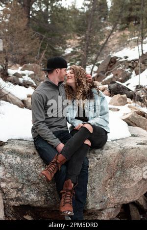 Couple aventureux assis ensemble dans les montagnes du Colorado en hiver Banque D'Images