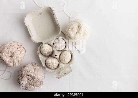 Ensemble d'œufs crochetés de pâques mignons, couleur pastel dans la boîte à œufs Banque D'Images