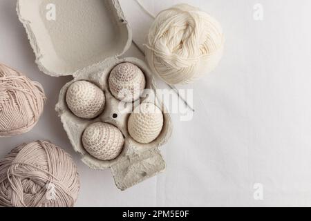 Ensemble d'œufs crochetés de pâques mignons, couleur pastel dans la boîte à œufs Banque D'Images