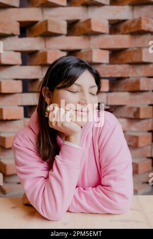 portrait d'une femme hispanique souriant avec les yeux fermés Banque D'Images