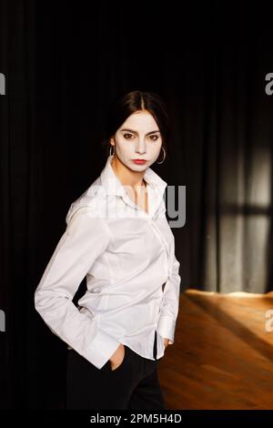 Jeune actrice dans un costume avec maquillage blanc dans le théâtre de répétition Banque D'Images