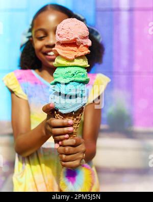 Jeune fille souriant tout en mangeant de la glace arc-en-ciel en Virginie Banque D'Images