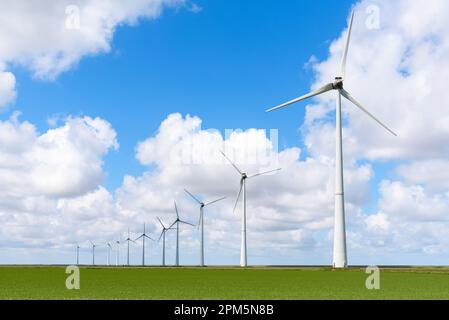 Rangée d'éoliennes sous ciel bleu avec nuages en été Banque D'Images