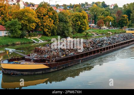 Industrie du transport. La barge transporte la ferraille et le sable avec du gravier. Une barge chargée de ferraille se trouve sur la chaussée. Ferraille Banque D'Images