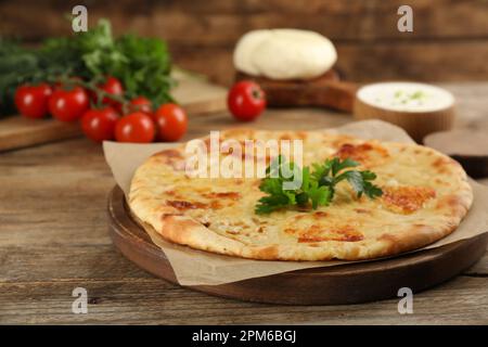 Délicieux khachapuri avec du fromage sur une table en bois Banque D'Images