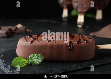 Délicieuse glace glacée glacée et menthe sur table noire, en gros plan Banque D'Images