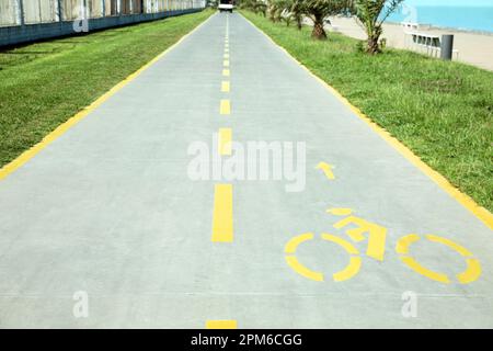 Piste cyclable avec panneau jaune peint et flèche Banque D'Images