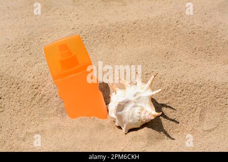 Bouteille avec spray de protection solaire et mouillage sur la plage de sable Banque D'Images