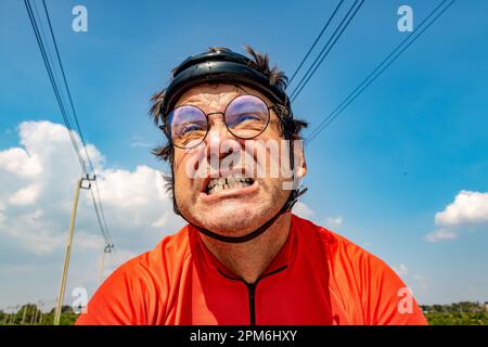 Un cycliste en activité roule sous un ciel bleu Banque D'Images