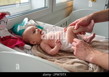 Père changeant de couches de petite fille mignonne Banque D'Images