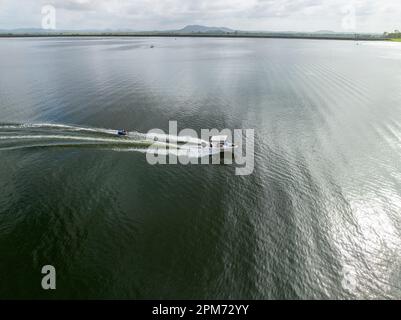 MacKay, Queensland, Australie - avril 2023 : drone aérienne d'un bateau à moteur remorquant des enfants sur des tubes à travers le barrage de Kinchant Banque D'Images