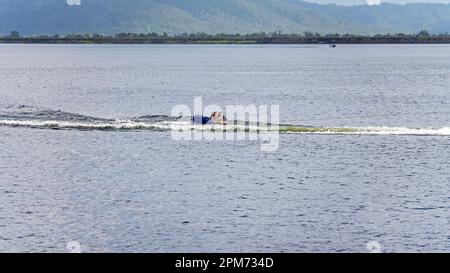 MacKay, Queensland, Australie - avril 2023 : drone aérienne d'un bateau à moteur remorquant des enfants sur des tubes à travers le barrage de Kinchant Banque D'Images