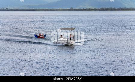 MacKay, Queensland, Australie - avril 2023 : drone aérienne d'un bateau à moteur remorquant des enfants sur des tubes à travers le barrage de Kinchant Banque D'Images