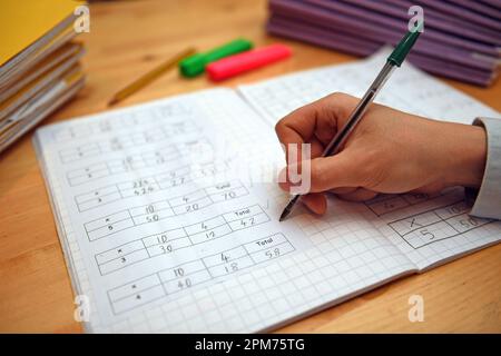 Photo du dossier datée du 05/03/2017 d'un enseignant de l'école primaire marquant les devoirs de mathématiques d'un élève. La quantité de temps que les parents consacrent à aider leurs enfants à faire leurs devoirs contribue beaucoup moins à leurs progrès à l'école que la classe sociale de la famille, a suggéré une étude. Date de publication : mercredi 12 avril 2023. Banque D'Images