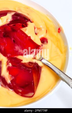 gelée et crème anglaise dans une tasse de verre isolée sur blanc Banque D'Images