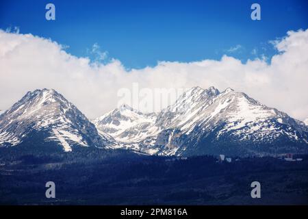 arrière-plan nature de la puissante crête de tatra au printemps à midi. sommets rocheux enneigés sous un ciel nuageux Banque D'Images