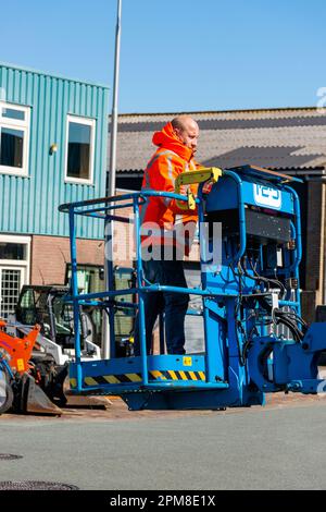 homme debout sur une plate-forme bleue d'une grue mobile Banque D'Images